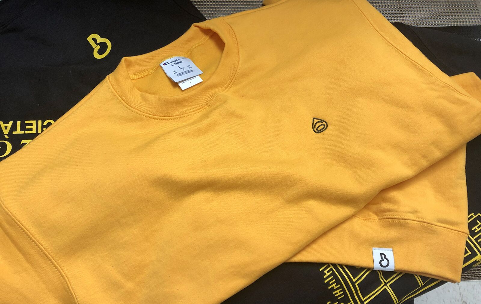 A crewneck sweatshirt with an embroidered business logo.